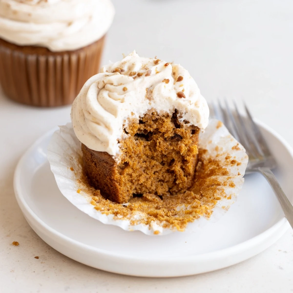 Moist root beer pumpkin cupcakes topped with cream cheese frosting, perfect for fall gatherings.