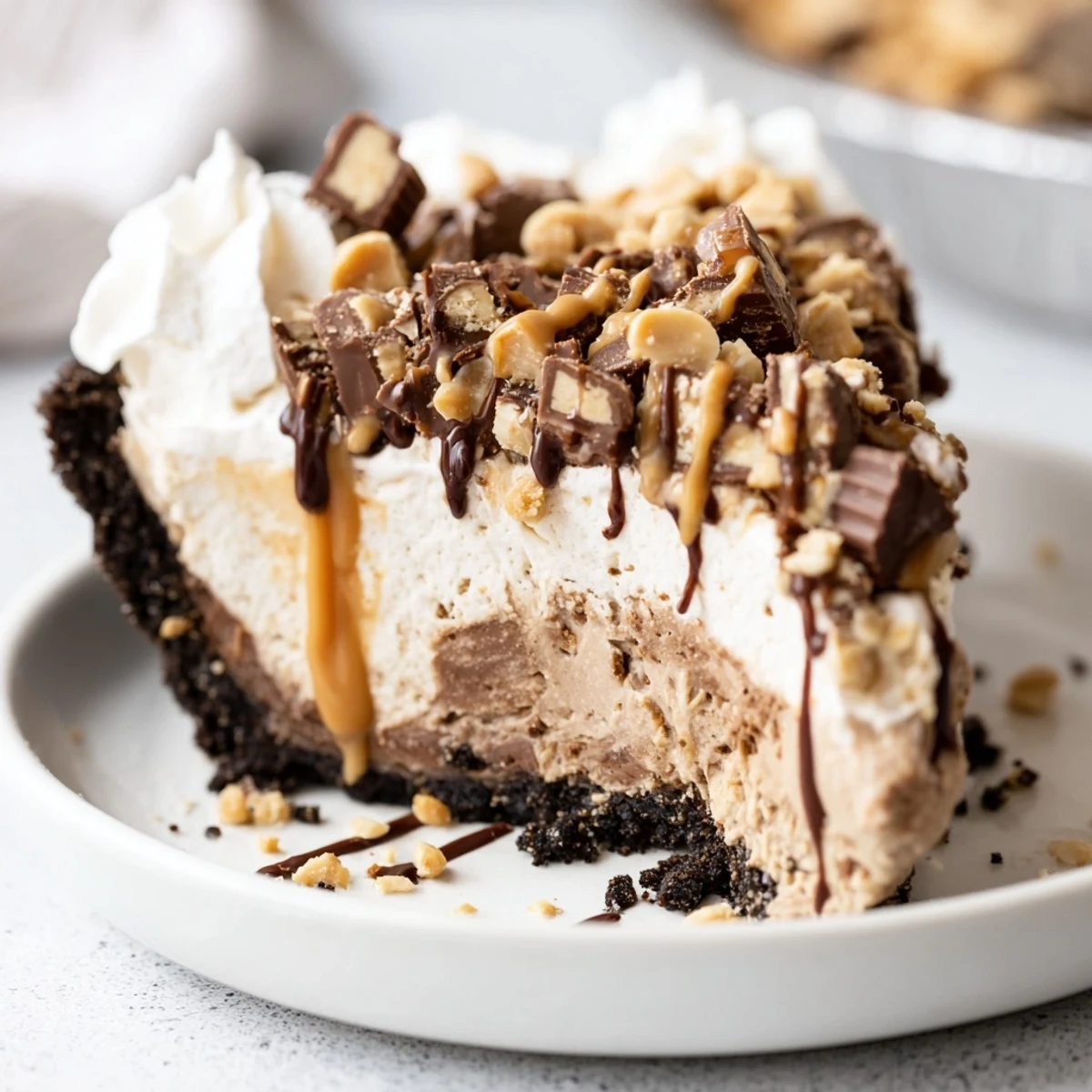 A tempting Snickers soda float pie topped with peanuts, chocolate, and caramel drizzles.  