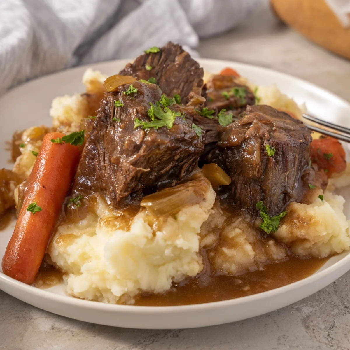 Hearty Slow Cooker Pot Roast melts in your mouth, alongside buttery mashed potatoes.  