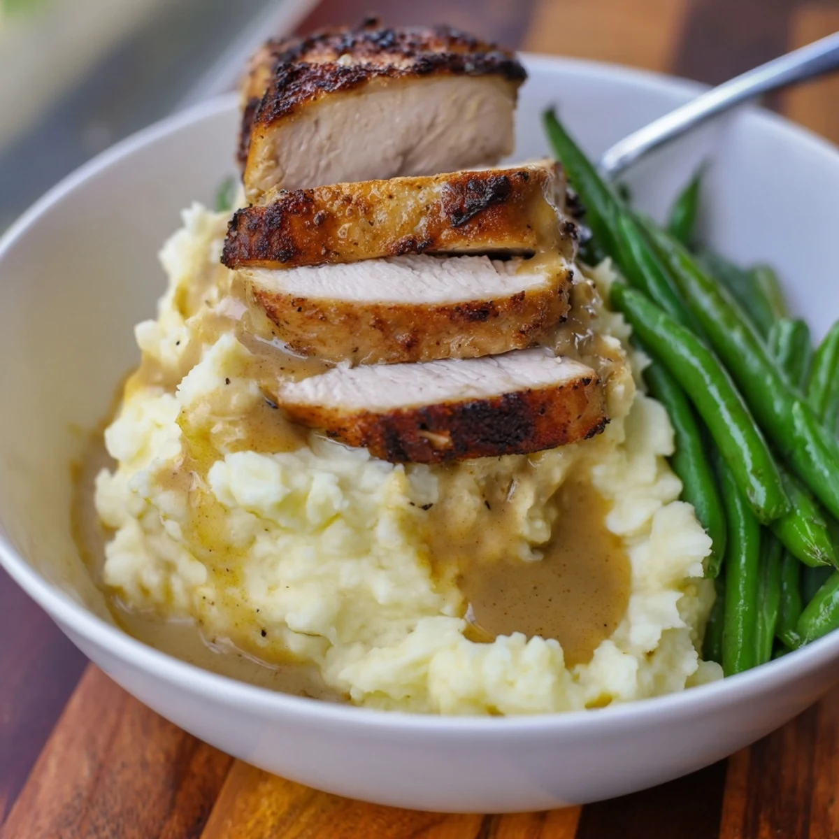 Tender seared pork chops over fluffy cheddar mash, finished with bright green beans.