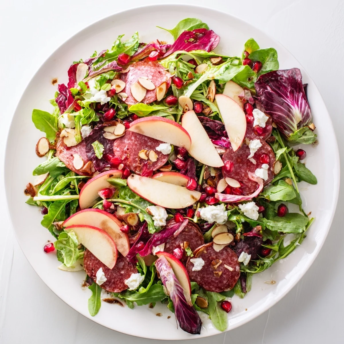 Vibrant Hot Girl Christmas Salad with salami, juicy pomegranate seeds, and a creamy cheese crumble.