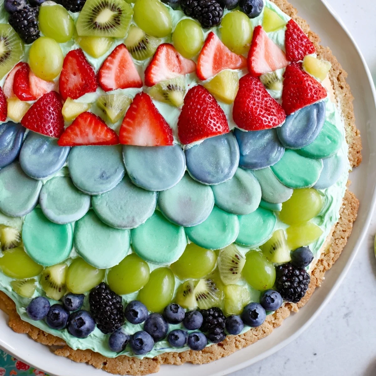 Under the Sea Mermaid Tail Fruit Pizza, a colorful dessert with a creamy frosting and fresh fruit.