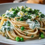 Spring pasta dish featuring al dente linguine, fresh peas, and zesty lemon ricotta for a light, satisfying meal.  