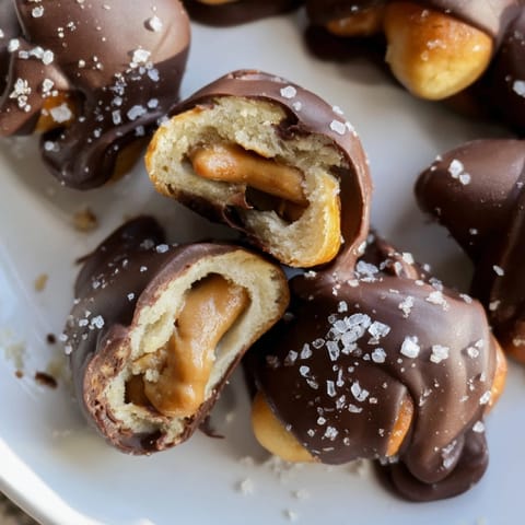 Homemade Peanut Butter Salted Pretzel Bites glistening with chocolate on a baking sheet.