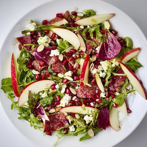 A colorful bowl of Hot Girl Christmas Salad, featuring savory salami and a tangy balsamic dressing.