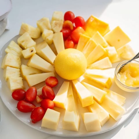 Vibrant arrangement of a Citrus Burst platter with colorful fruit and savory cheeses on display.