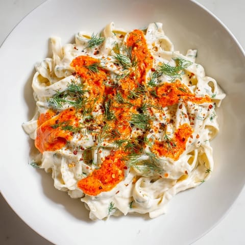 Steamy bowl of Turkish Pasta with Paprika Butter, garnished with fresh herbs and pepper.