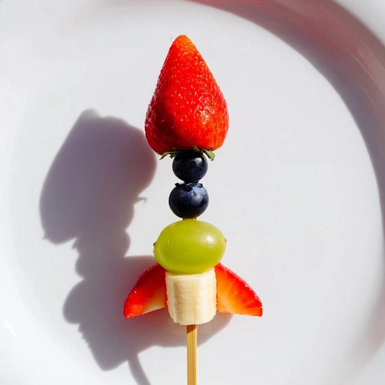 Fresh Rocket Ship Fruit Skewers featuring pineapple flames, green grapes, and a strawberry tip.