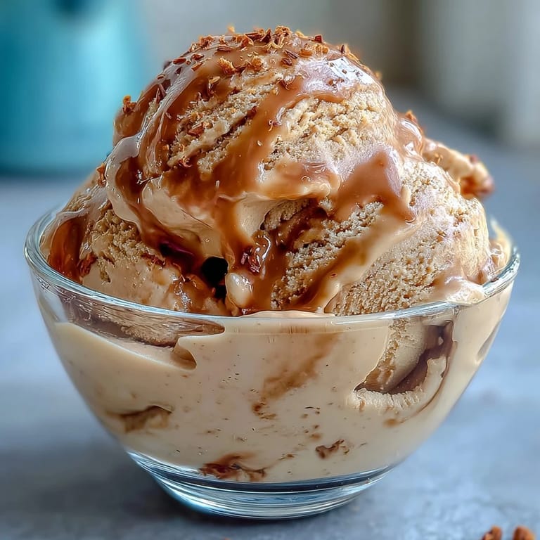 A close-up scoop of Hojicha Ice Cream revealing a velvety texture, garnished with toasted sesame seeds.